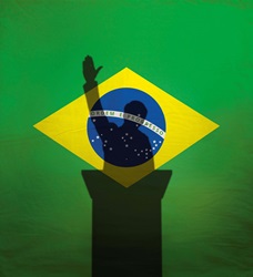 Politician with raised arm over Brazil flag