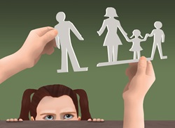 Girl looking at paper cut outs representing separated family