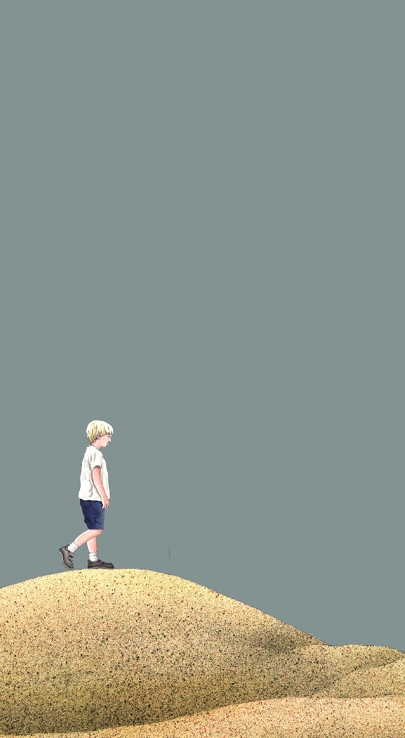 Boy standing on sand dune