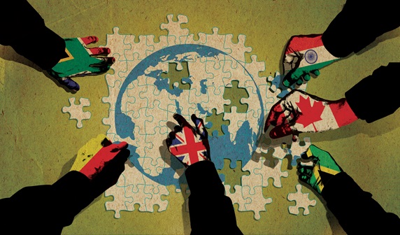 Hands covered with various national flags making jigsaw puzzle