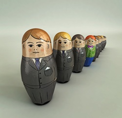 Smiling brightly dressed businessman standing out in row of serious nesting dolls