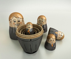 Small crying businessman revealed inside of open nesting dolls in order of size and happiness