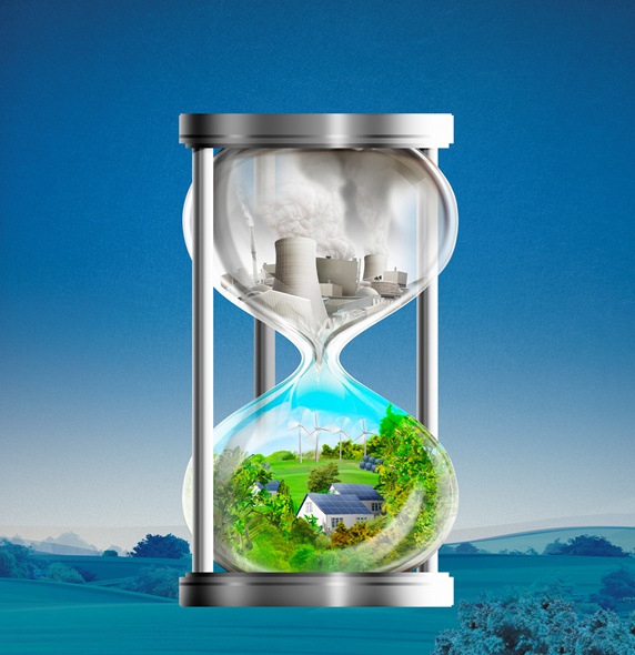 Hourglass with idyllic green energy contrasting with fossil fuel power station 