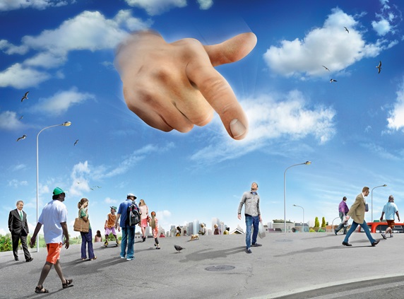 Large hand in sky pointing to man standing out from the crowd