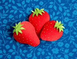 Paper strawberries on blue background