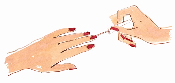 Close up hands of woman painting fingernails with red nail polish
