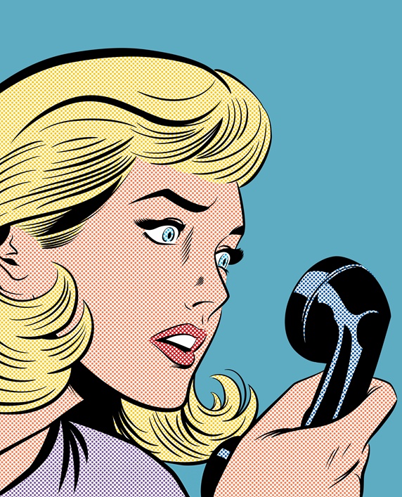 Close up of woman with stunned facial expression staring at telephone receiver