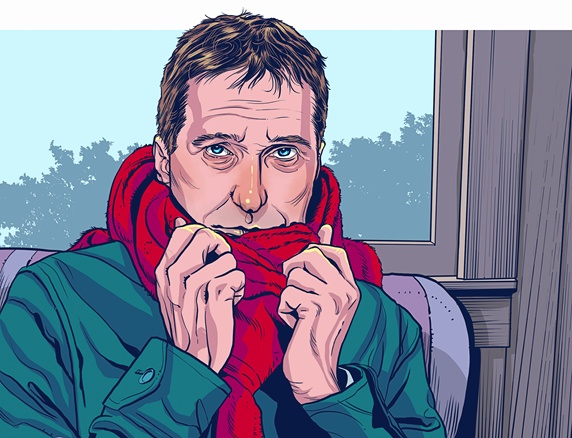Man feeling cold sitting indoors wrapped in scarf