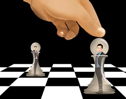 Hand moving chess piece with man inside
