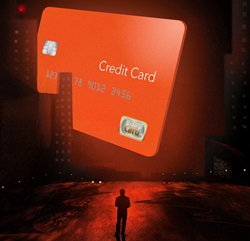 Silhouette of man facing large credit card in city at night